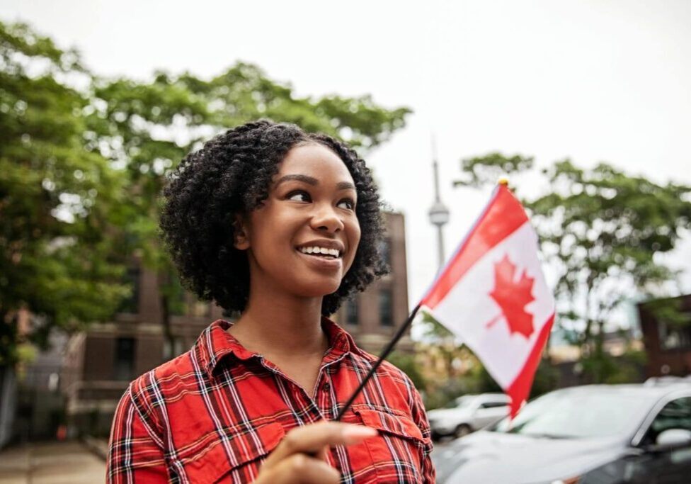 Newcomer in Toronto holding a Canadian flag for immigration planning from Israel to Canada